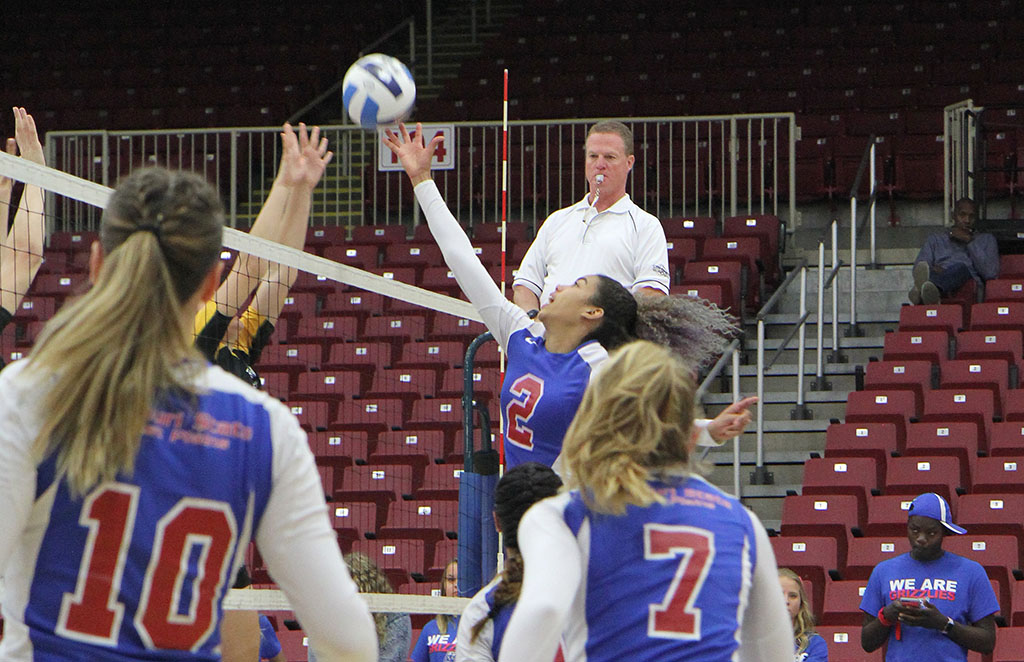 Grizzly outside hitter Camilly Cristiny (No. 2) tips the ball over the net during the Colton's Steak House & Grill/Lazy W Pallets Grizzly Invitational Tournament. Looking on are teammates Tatjana Trifkovic (No. 10) and Julia Dunning (No. 7). (Missouri State-West Plains Photo)