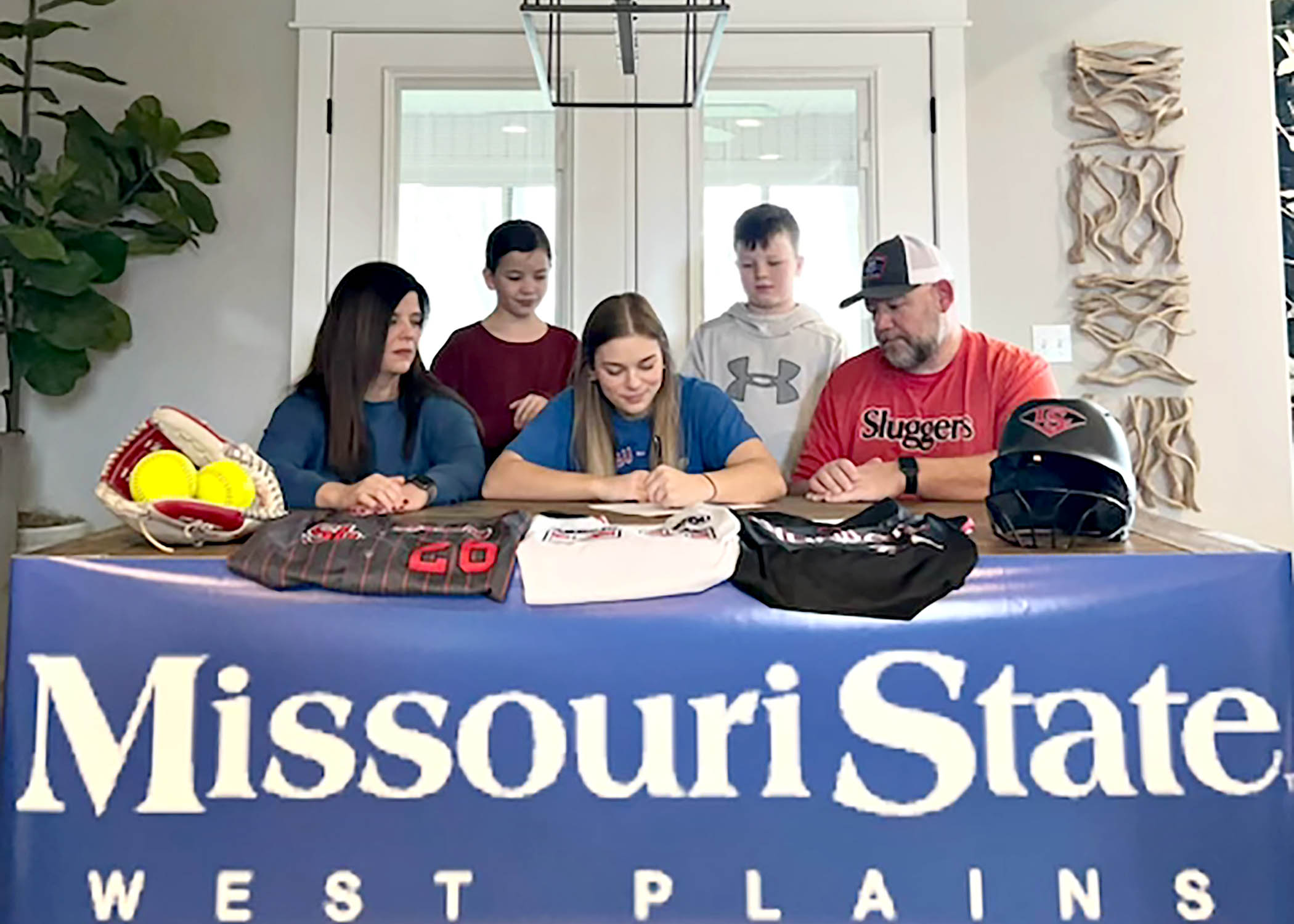 Maddie Saul, seated center, signs her letter of intent to play for the Grizzly Softball team beginning in fall 2024. Looking on are her parents, Alison and Steve, and her siblings, Ava and Alex.